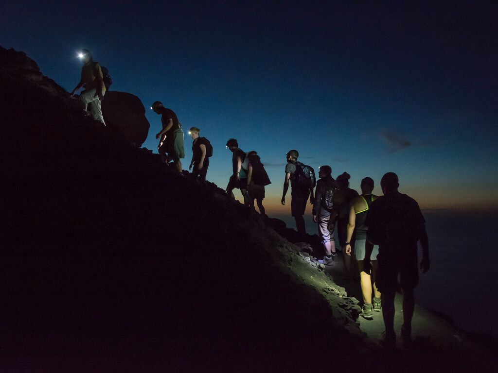 Marcha nocturna en grupo con linternas frontales